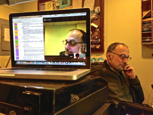 WRFUのスタジオでPCをネットにぎ各地から参加、パソコンの画面に番組構成表、画面右下がSt.LouisからRyutaさん。機材担当のTomさんが画面上でスタジオからの身振りとメッセージで合図（音楽、残り時間30秒、など）