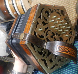 コンサティーナ。ボタンを押しながら蛇腹を押したり引いたりして音を出します。装飾がとても綺麗な楽器です。奥には打楽器のバウロンも見えます。@Ireland 2013 by Shimizu 